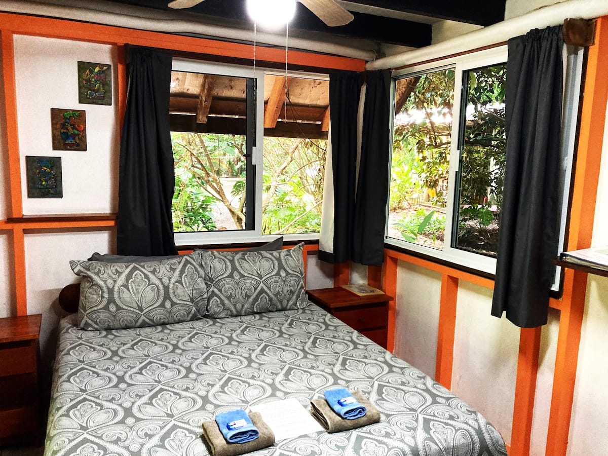The bright bedroom at Hummingbird Rest looking into the garden
